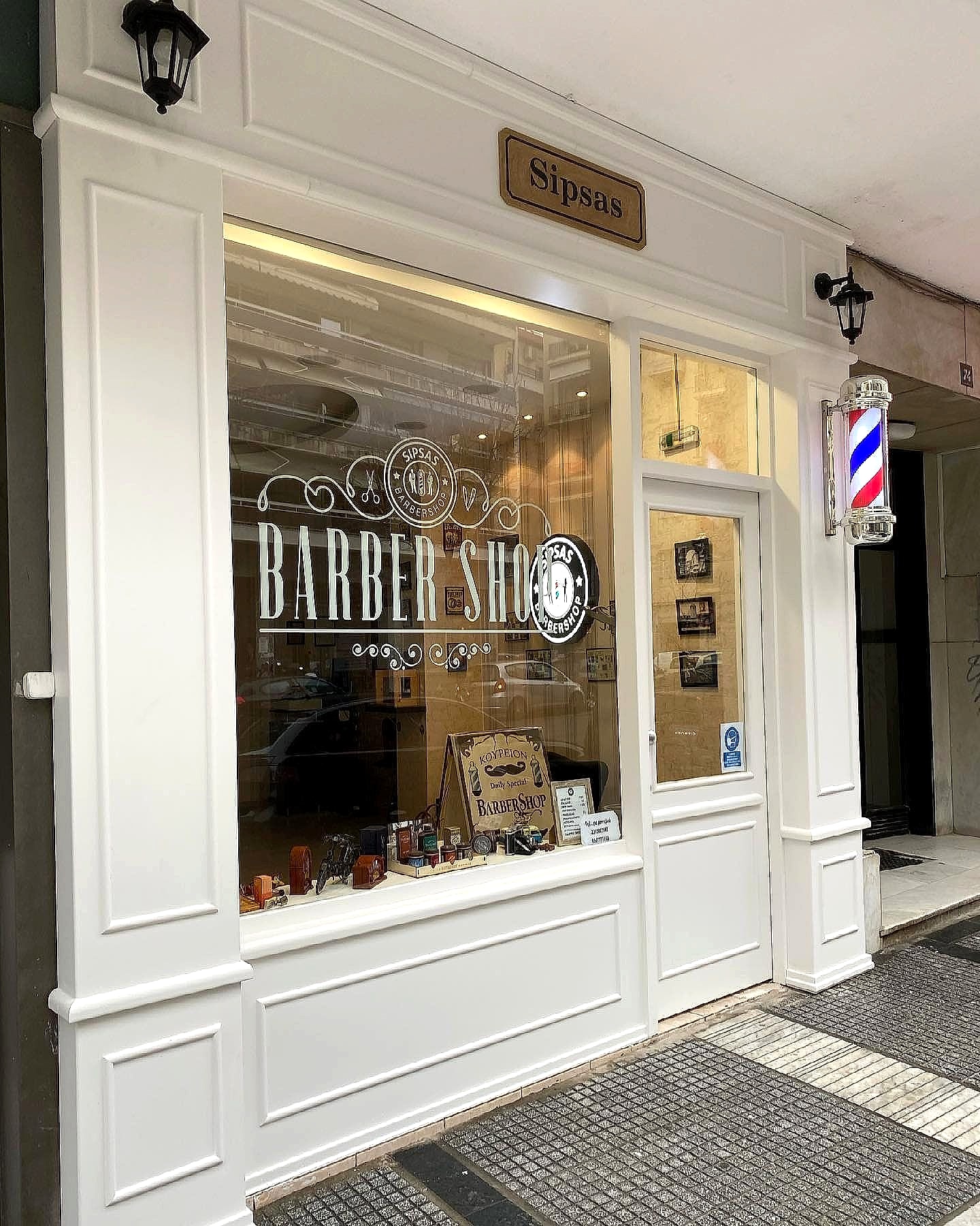 Η βιτρίνα του Sipsas Barber Shop στη Βασιλίσσης Όλγας, με την πινακίδα Sipsas και τη χαραγμένη επιγραφή Barber Shop